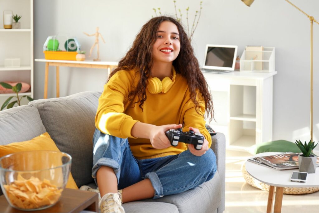 Menina sentada em um sofá jogando