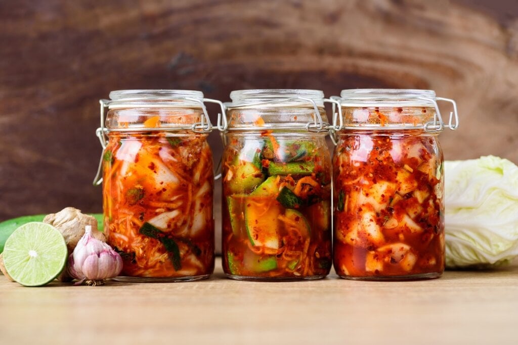 Kimchi em três recipientes de vidro tampados