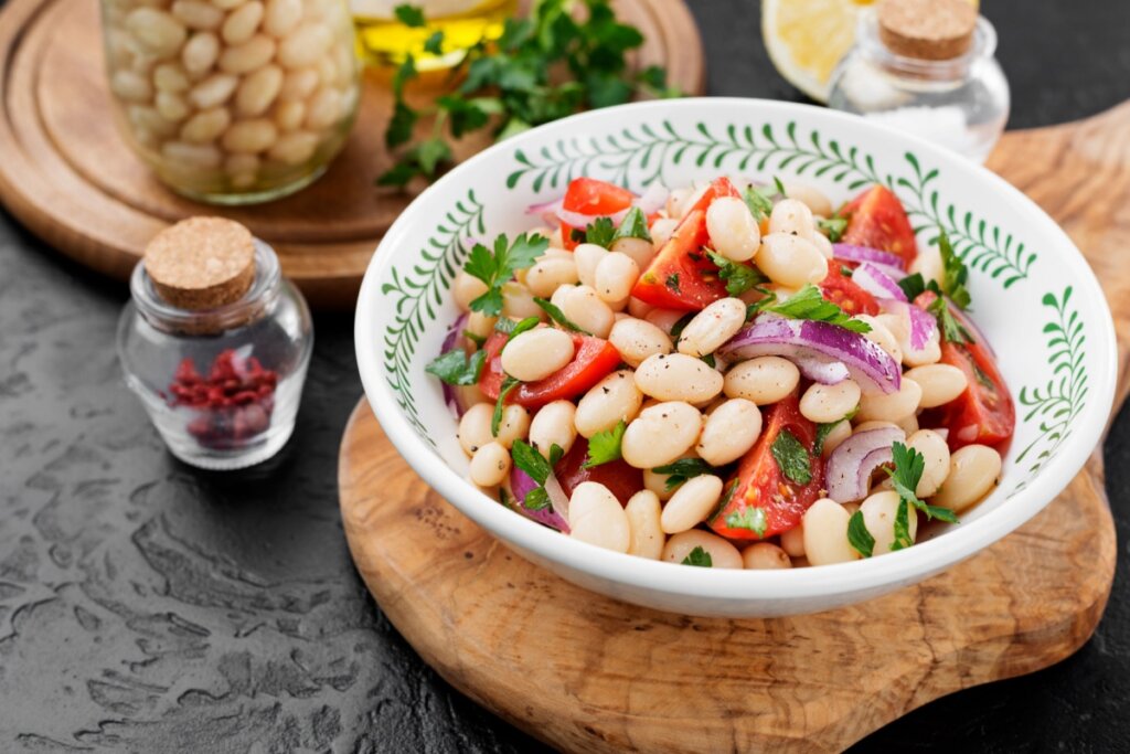 Salada de feijão branco com legumes em cumbuca branca