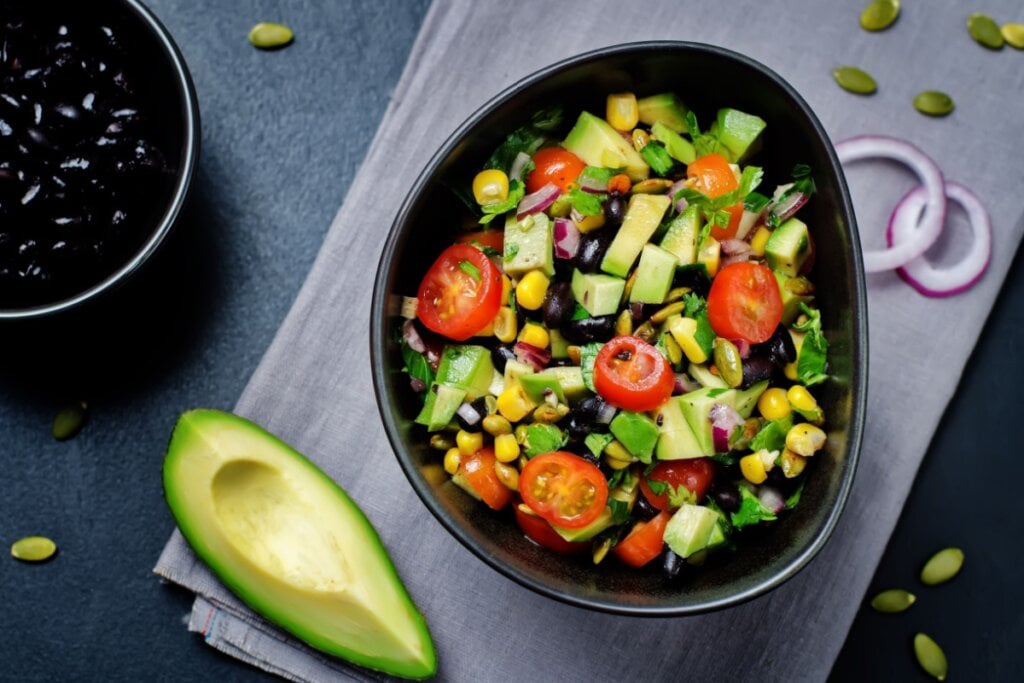 Salada de feijão-preto com abacate e milho em cima de uma mesa