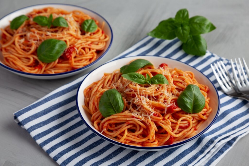 Spaghetti Pomodoro servido em dois pratos de porcelana branca e azul