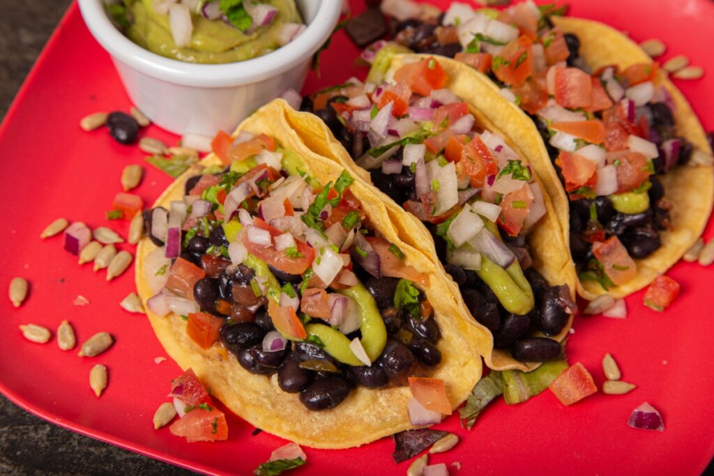 Tacos de feijão-preto em superfície vermelha