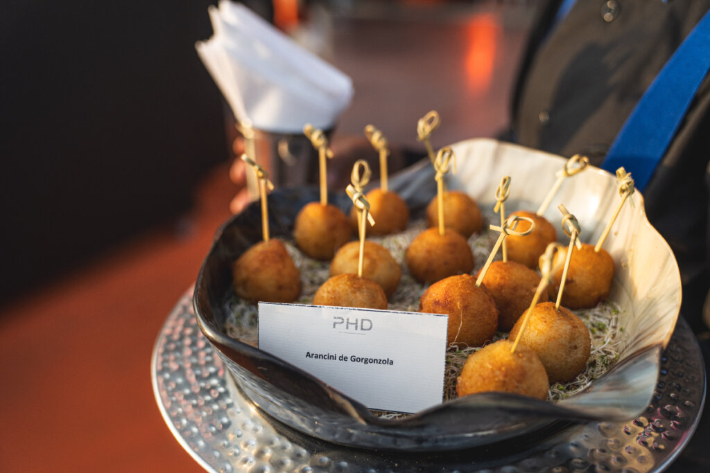 Arancini de gorgonzola com palitos decorados dentro de tigela 