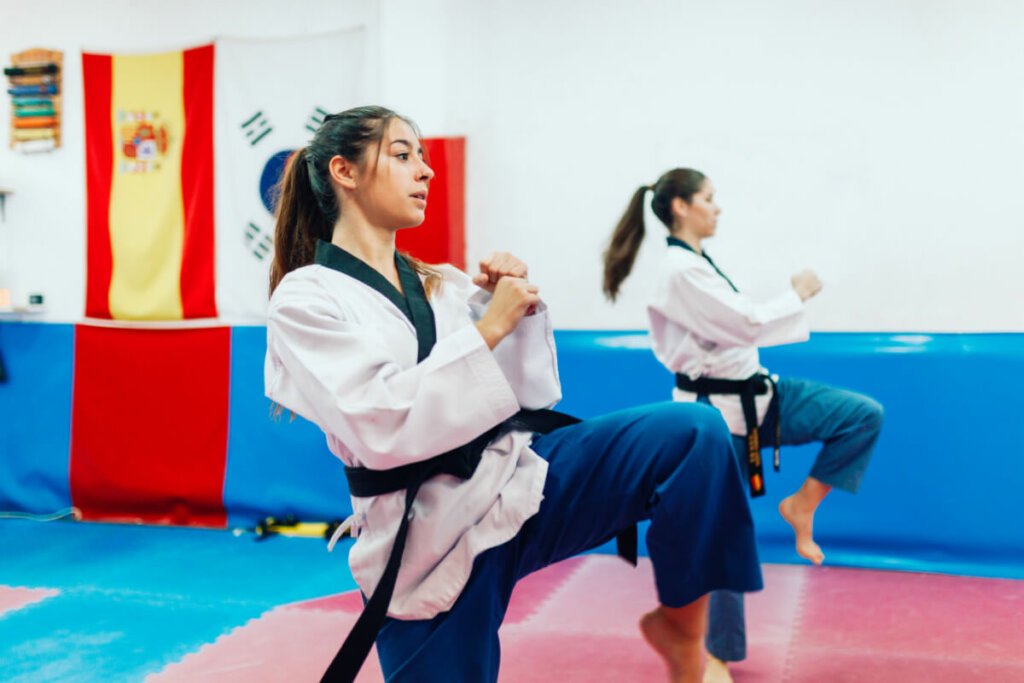 duas meninas lutando artes marciais na academia