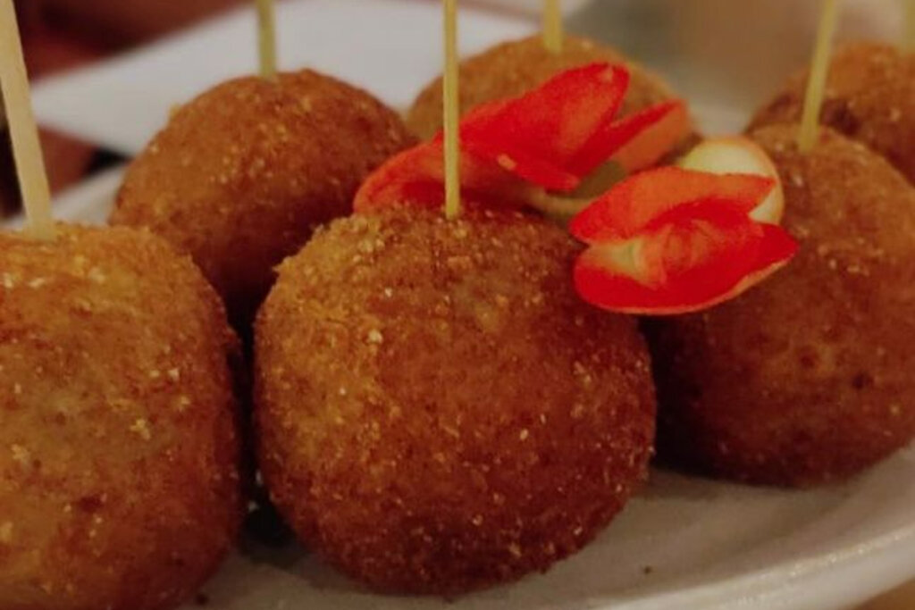 Bolinhos de bacalhau com palitos em um prato branco