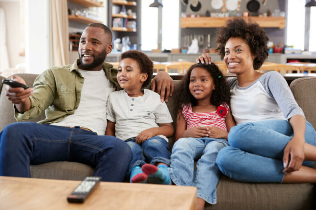 família assistindo televisão no sofá