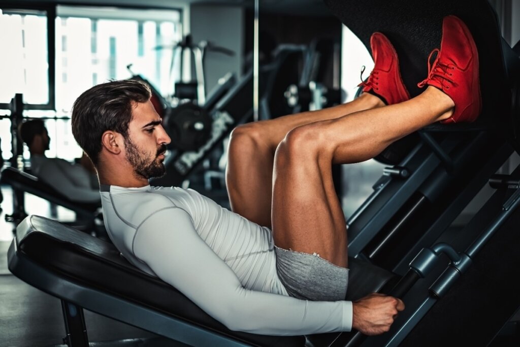 Homem fazendo legpress na academia 