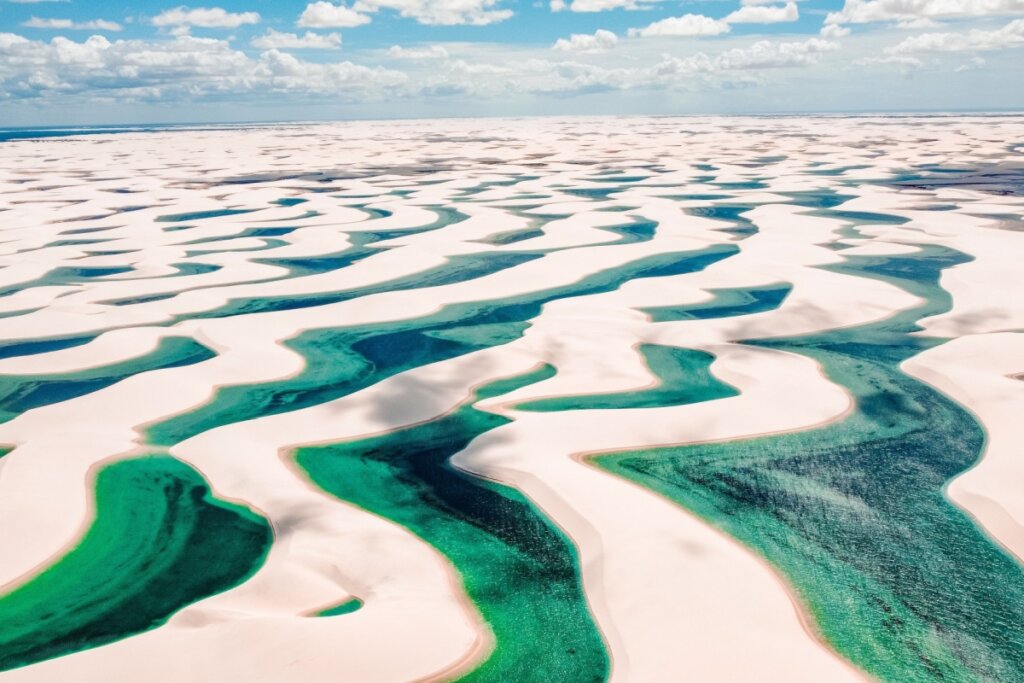 Paisagem aérea dos Lençóis Maranhenses com dunas de areia branca e lagoas azuis