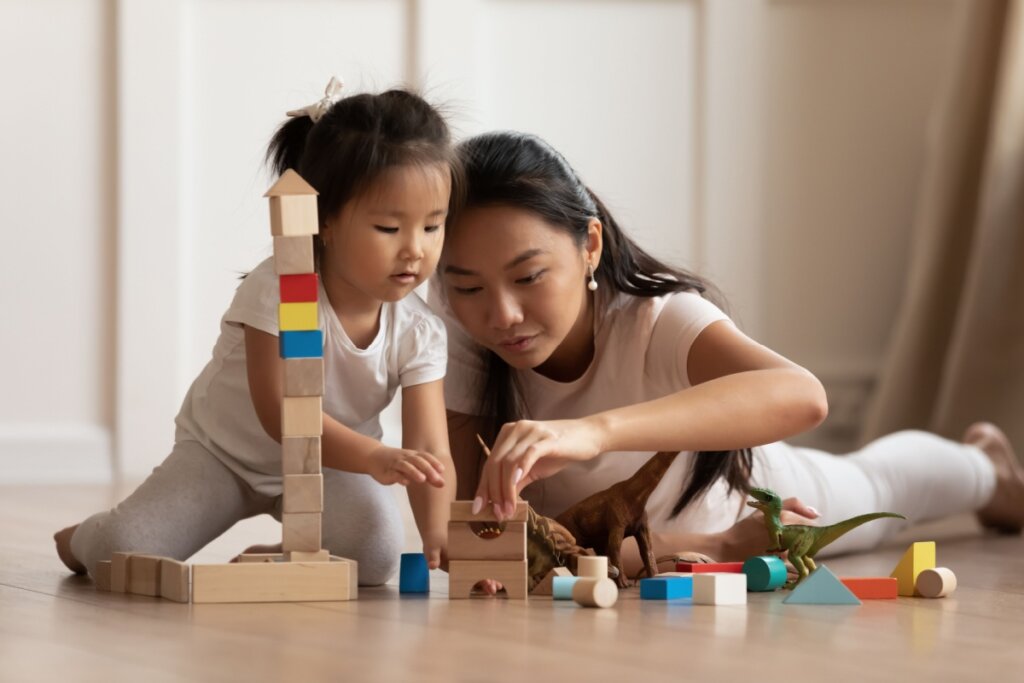 mãe e filha brincando com brinquedo de montar