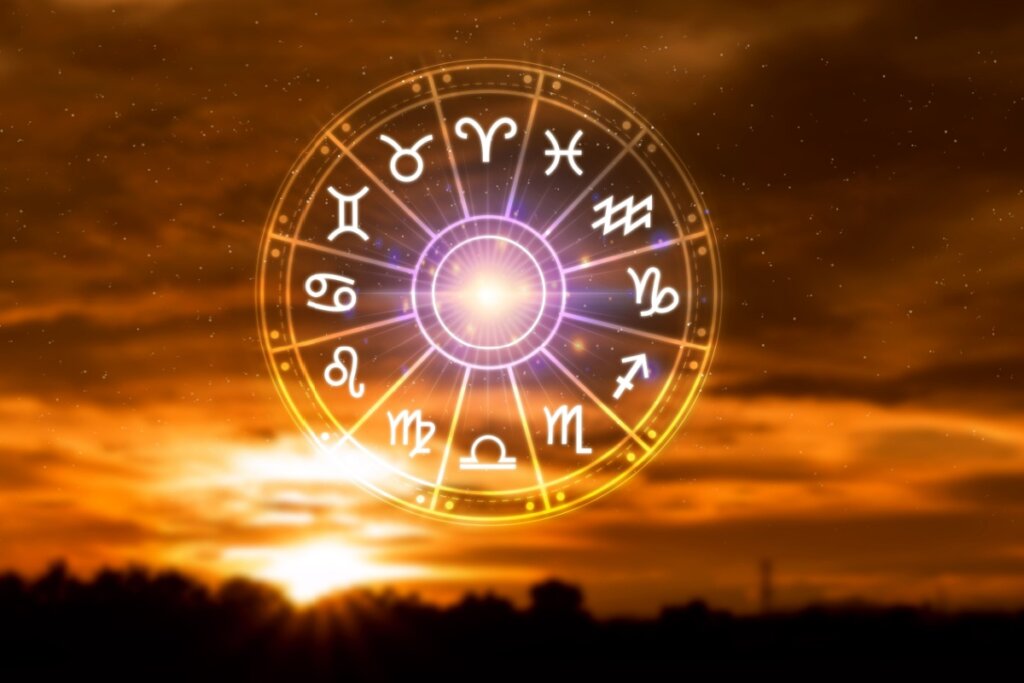 Madala com ilustração do símbolo dos 12 signos e céu com sol nascendo ao fundo