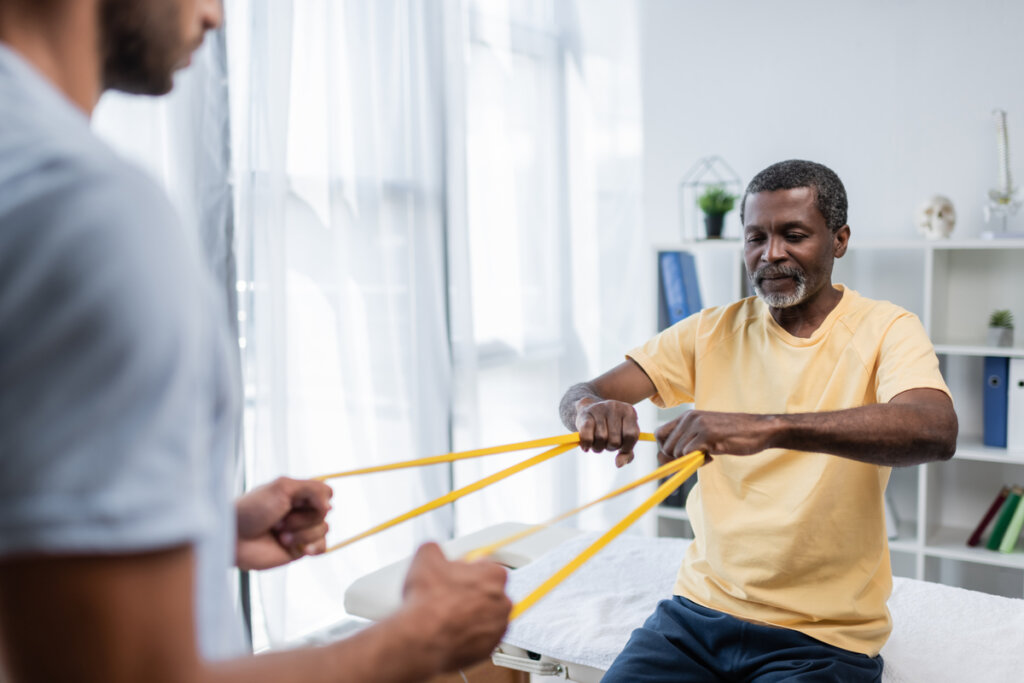 homem fazendo exercício com fisioterapeuta