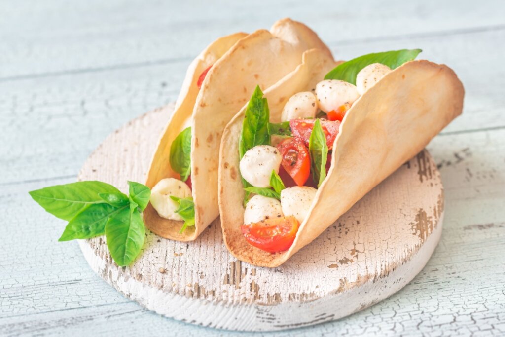 Tortilhas caprese sobre uma tábua de madeira branca desgastada