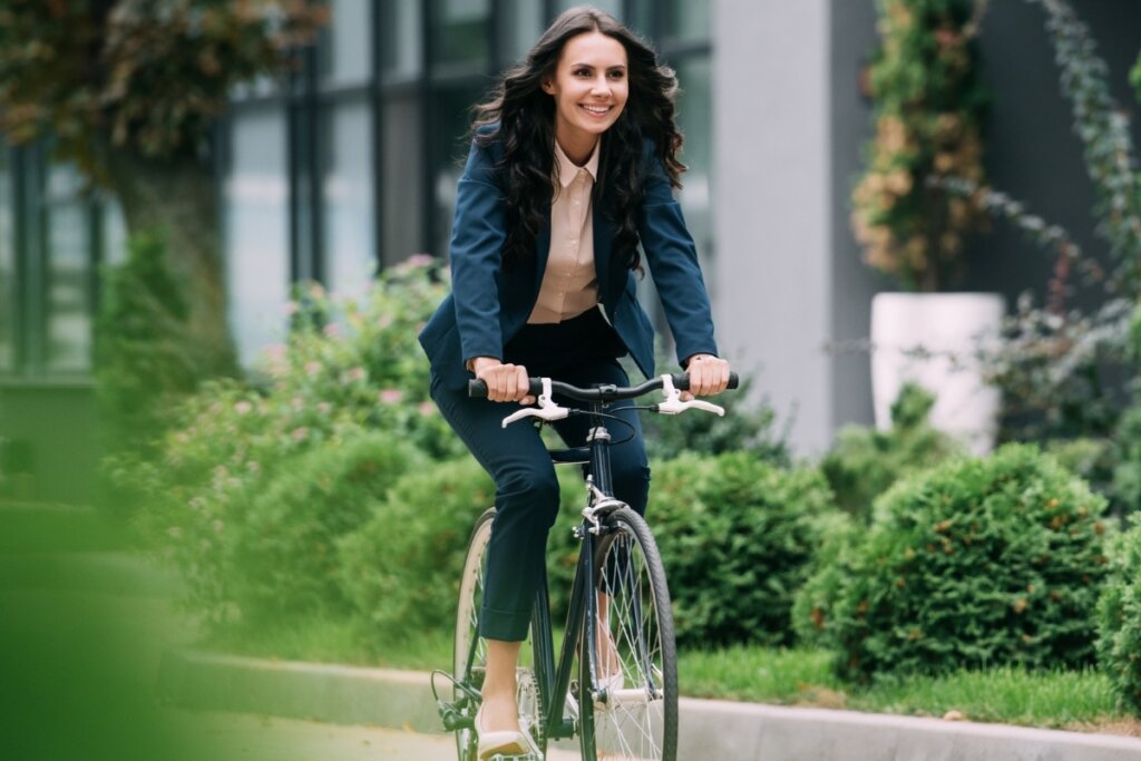 Mulher usando roupa social e andando de bicicleta