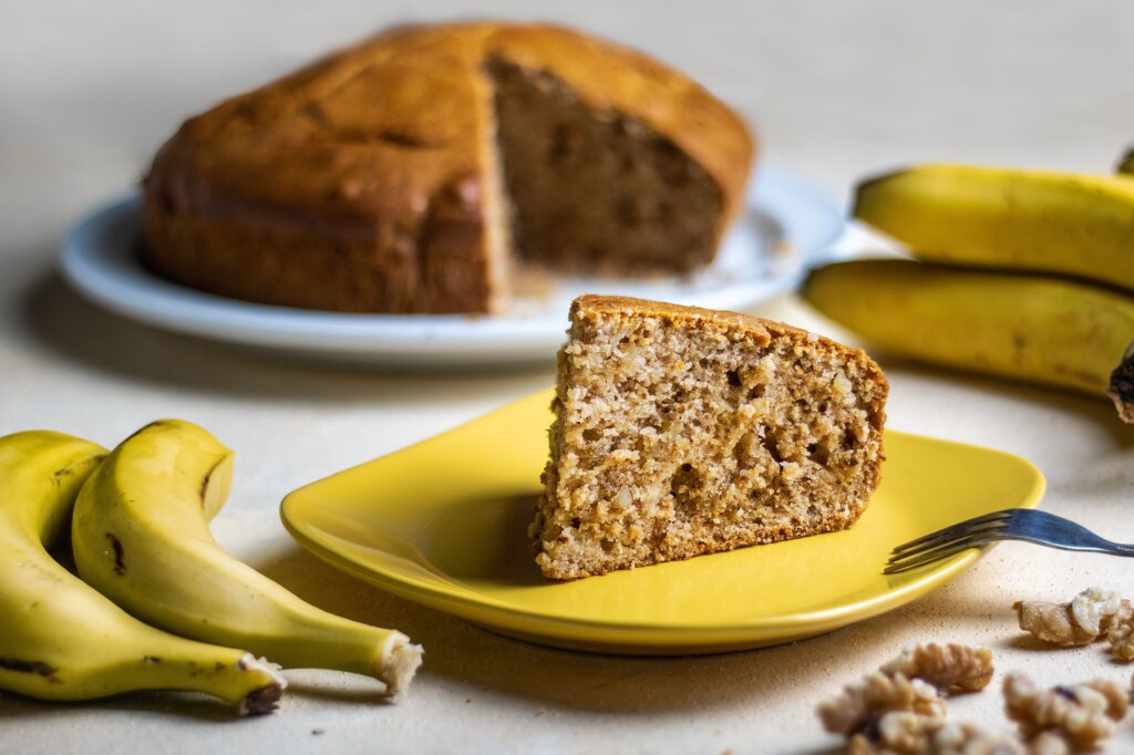 Bolo de casca de banana em prato amarelo em cima de uma mesa