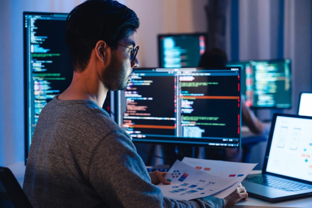 Homem sentado mexendo em um computador