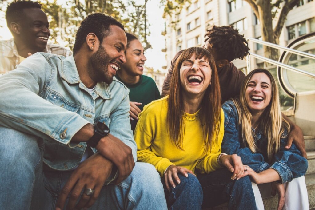 Pessoas sentadas em uma escada sorrindo felizes