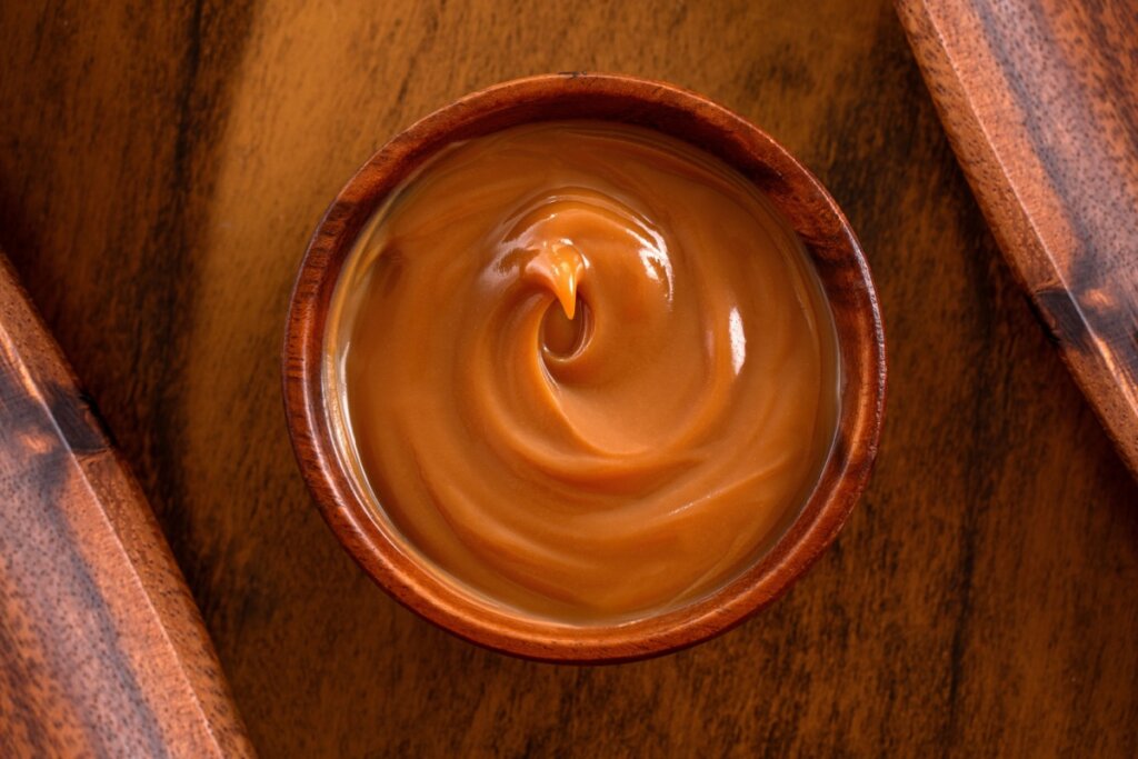 doce de leite em bowl em cima de uma mesa de madeira