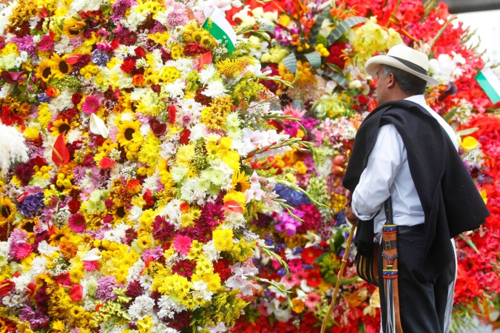 Homem olhando flores durante o desfile da Feira das Flores em Medellín