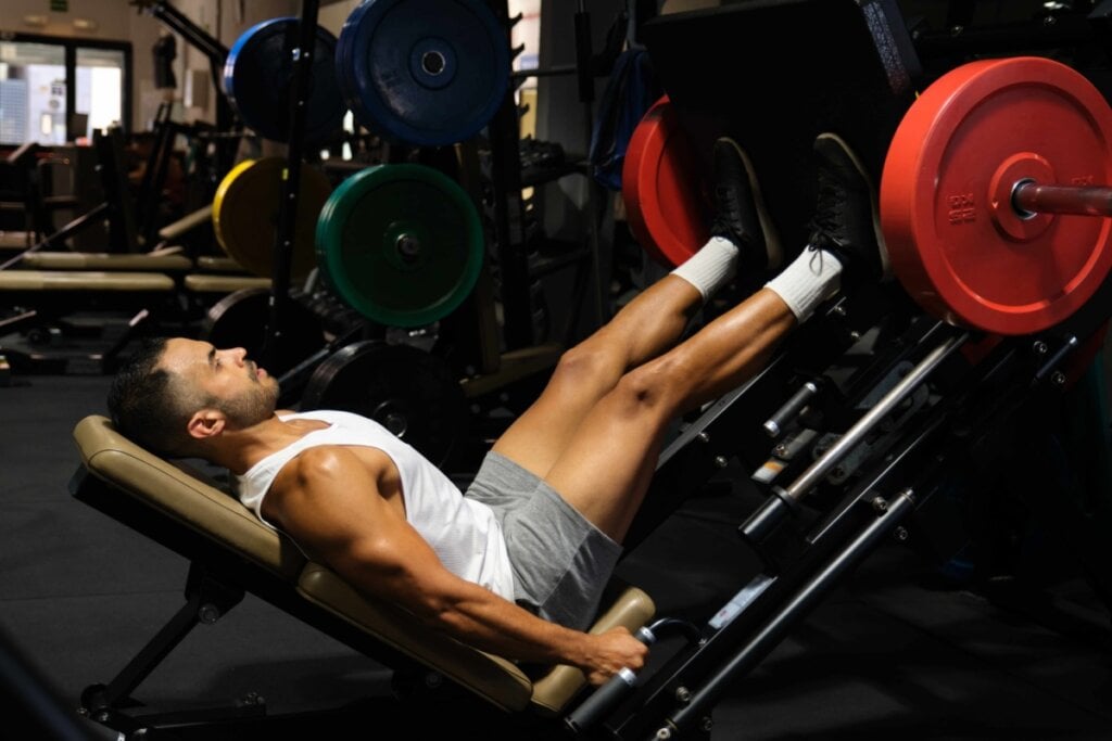 Homem fazendo flexão para panturrilha no leg press na academia 