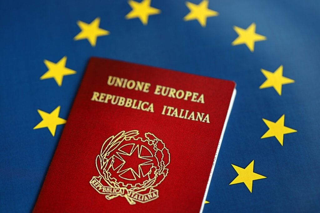 Passaporte italiano em cima da bandeira da União Europeia