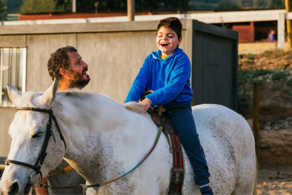 Homem guiando um cavalo com um menino