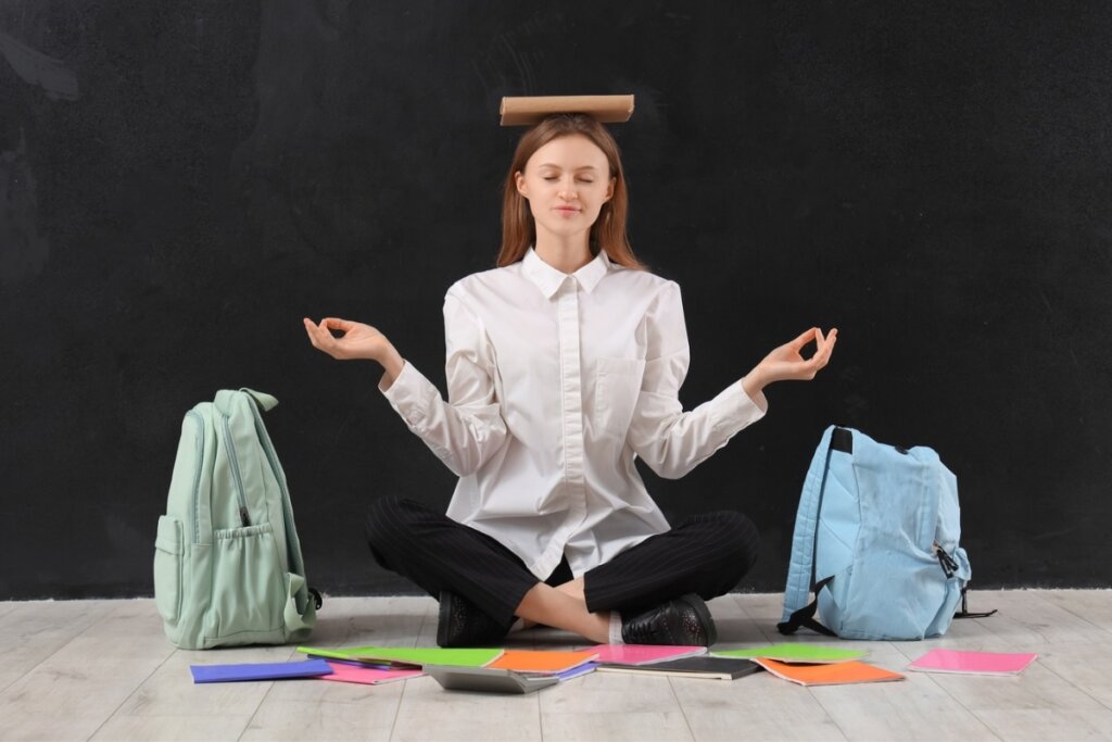 Mulher sentada com um livro na cabeça meditando