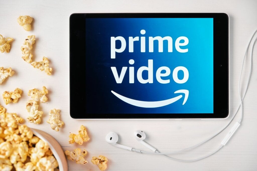 Pipocas em cima de uma mesa branca com um tablet com o logo do Prime Video