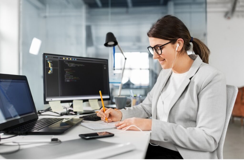 Mulher sentada programando algo em um computador