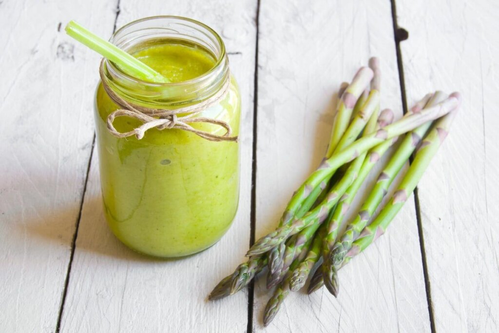 Copo de vidro suco verde e aipos ao lado