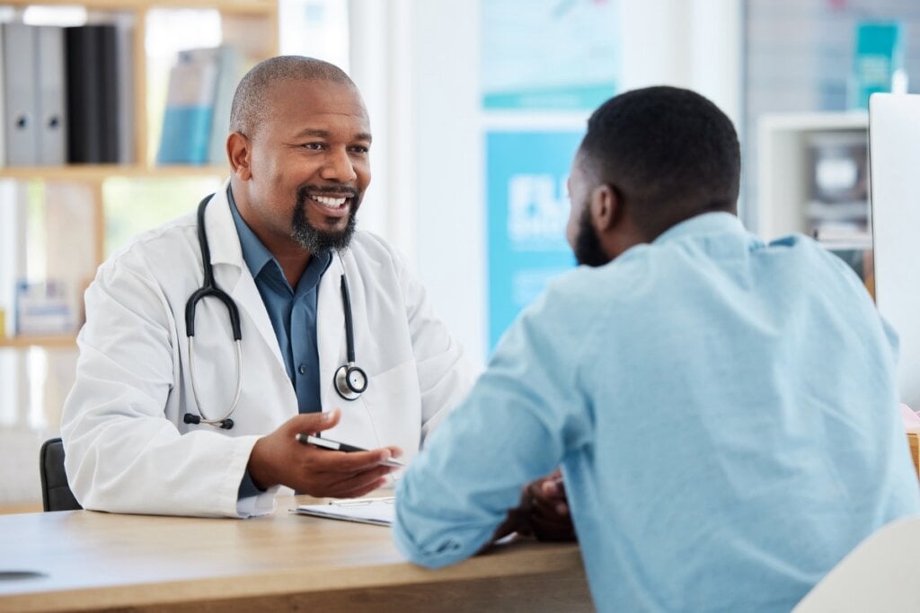 Homem e médico sentados conversando