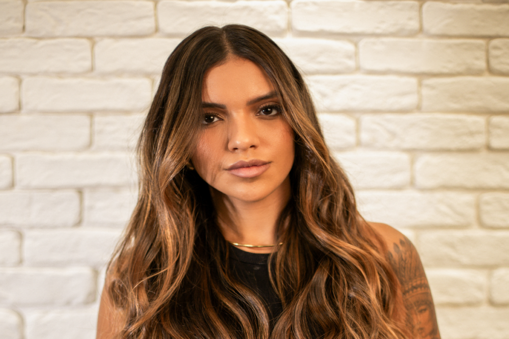 Mulher com cabelo pintado em tons de marrom e dourado posando para foto