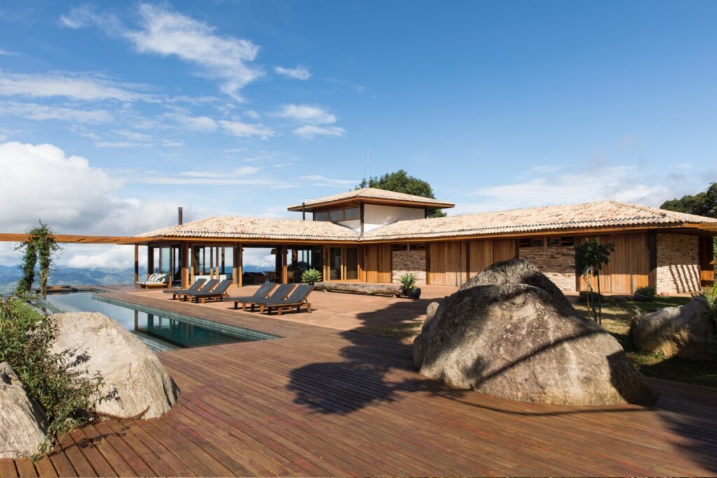 Casa com arquitetura integrada à madeira, piscina e deck, em harmonia com a paisagem natural