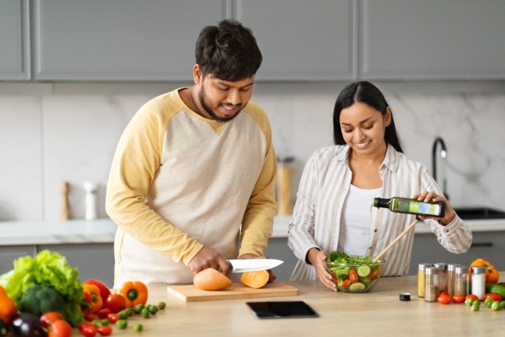 Jovens cozinhando uma refeição saudável na cozinha