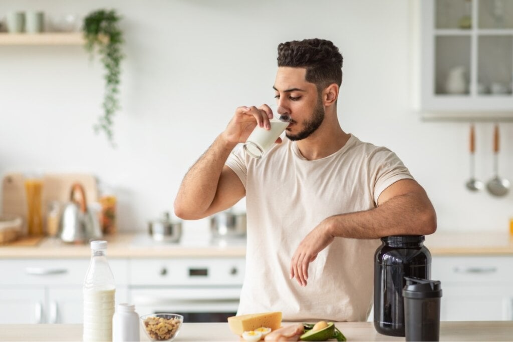 Homem tomando leite em um copo de vidro 