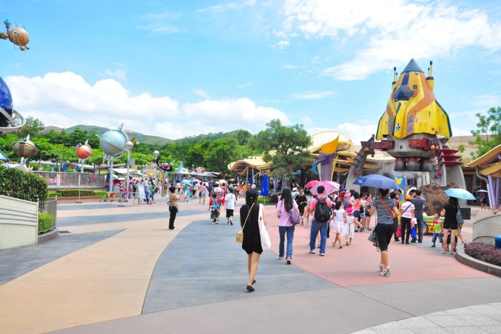 Área temática Tomorrowland no Magig Kingdom Park com céu azul e pessoas andando 