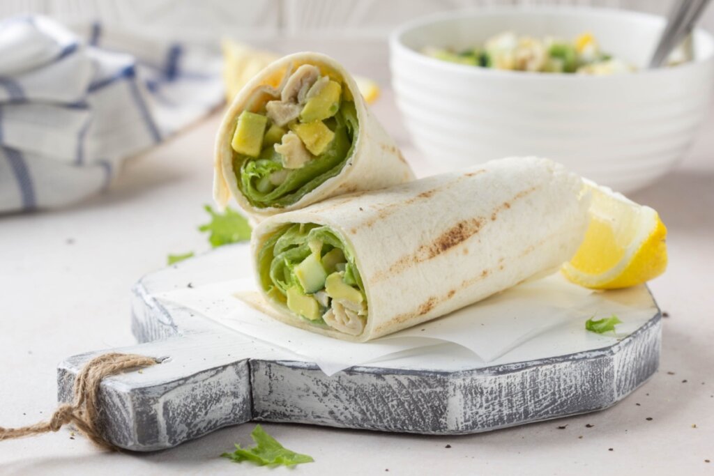 Wrap de frango com abacate cortado em tábua