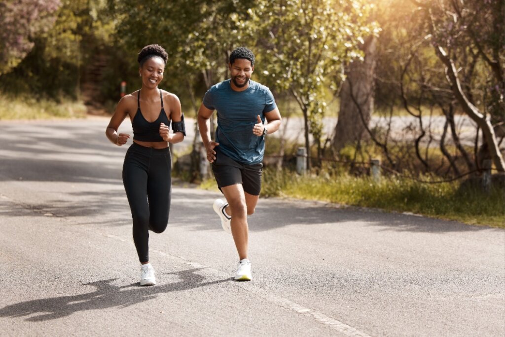 Homem e mulher com roupas esportivas correndo em rua