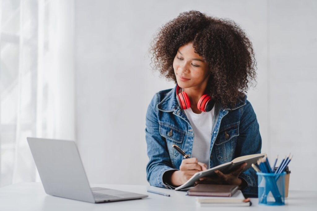 Jovem estudando para o vestibular e fazendo anotações