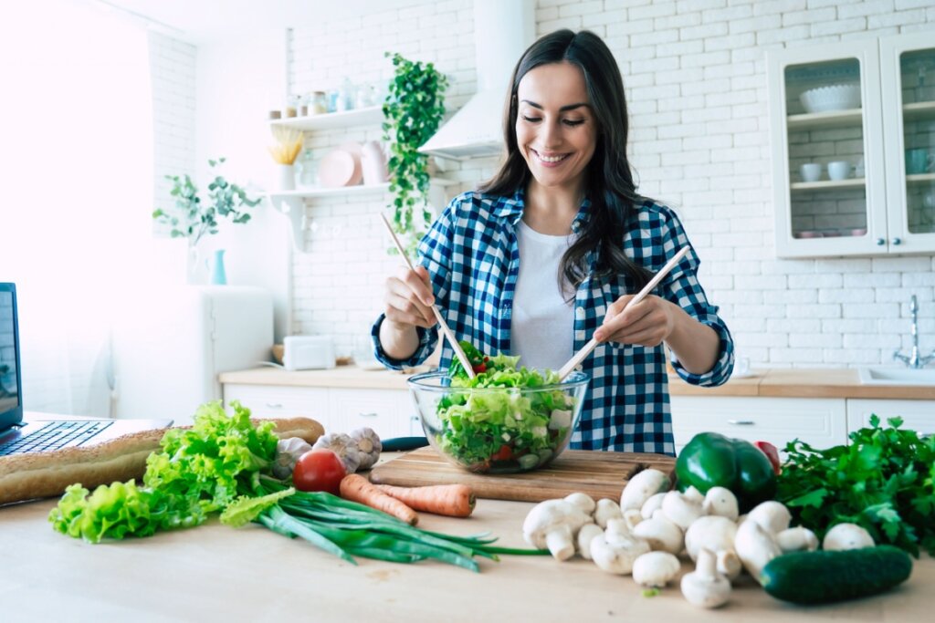 Jovem preparando refeição saudável com vegetais e verduras