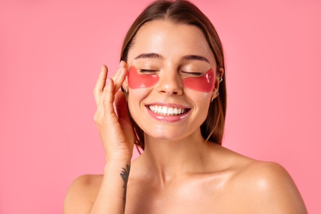 Mulher sorridente com máscaras para os olhos nas olheiras