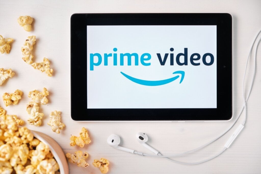 Tablet com logo do Prime Video, fone de ouvido e pipoca ao lado