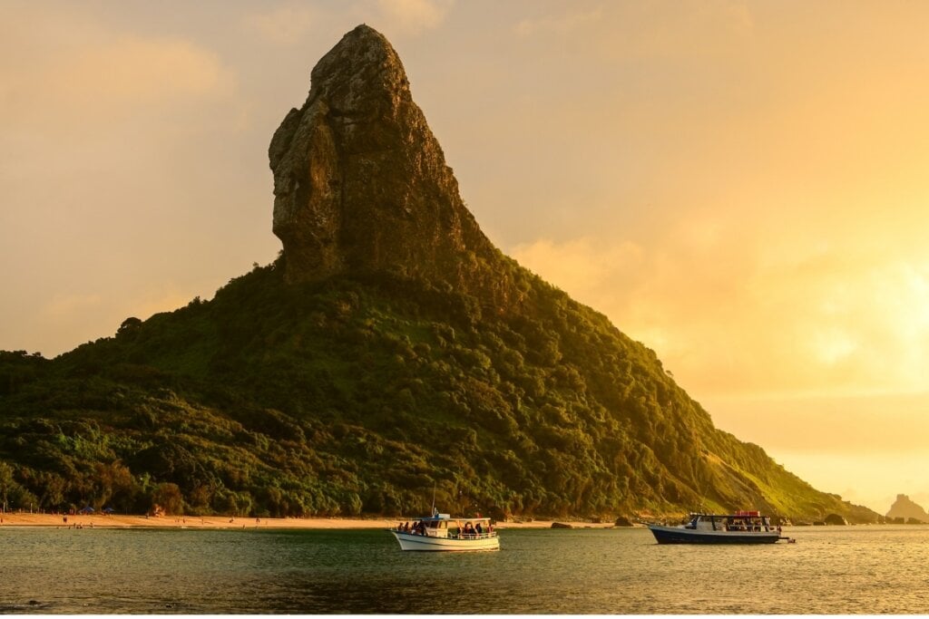 Vista de uma montanha na Praia da Conceição em pleno pôr do sol com o mar embaixo