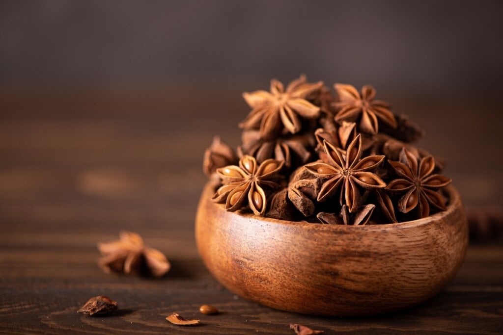 Pote de madeira com anis-estrelado em cima de mesa de madeira