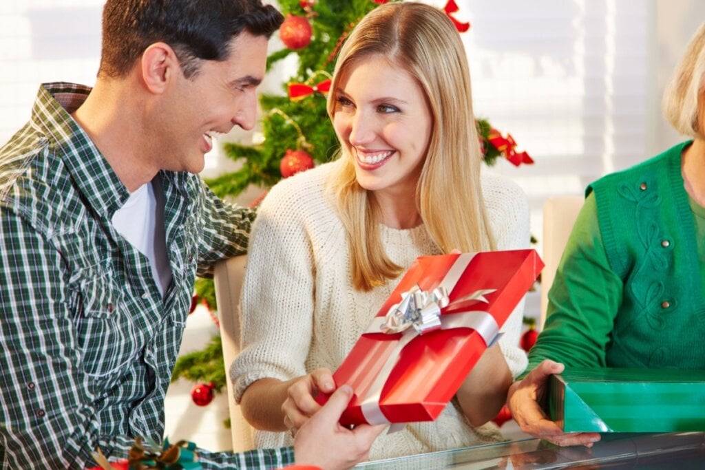 Homem dando presente de amigo secreto a mulher