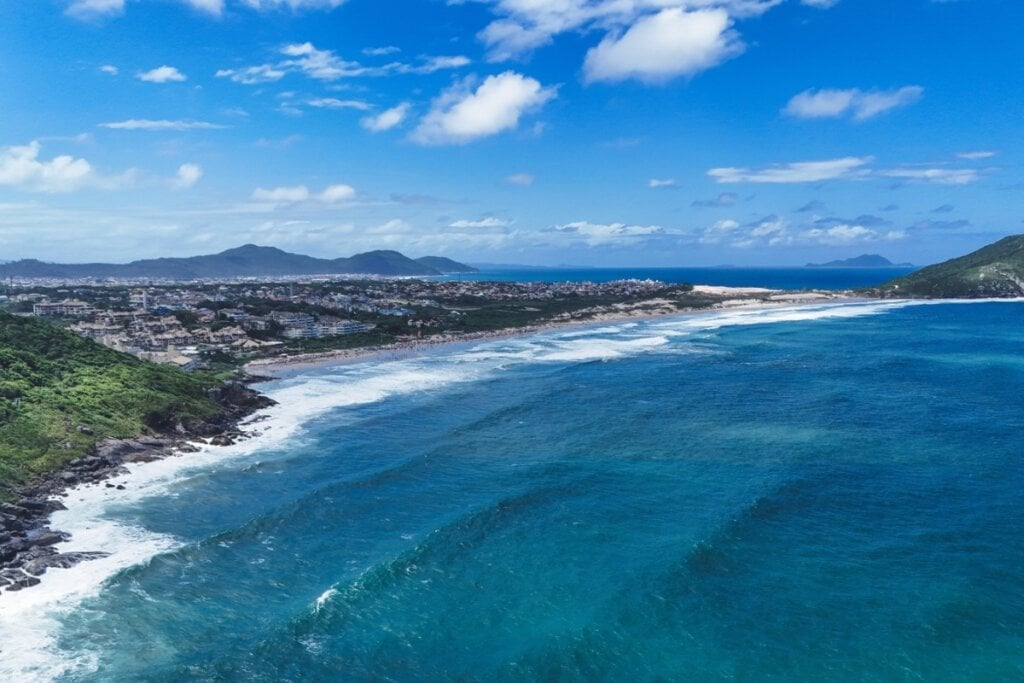 Imagem aérea de uma praia com água azul em Florianópolis