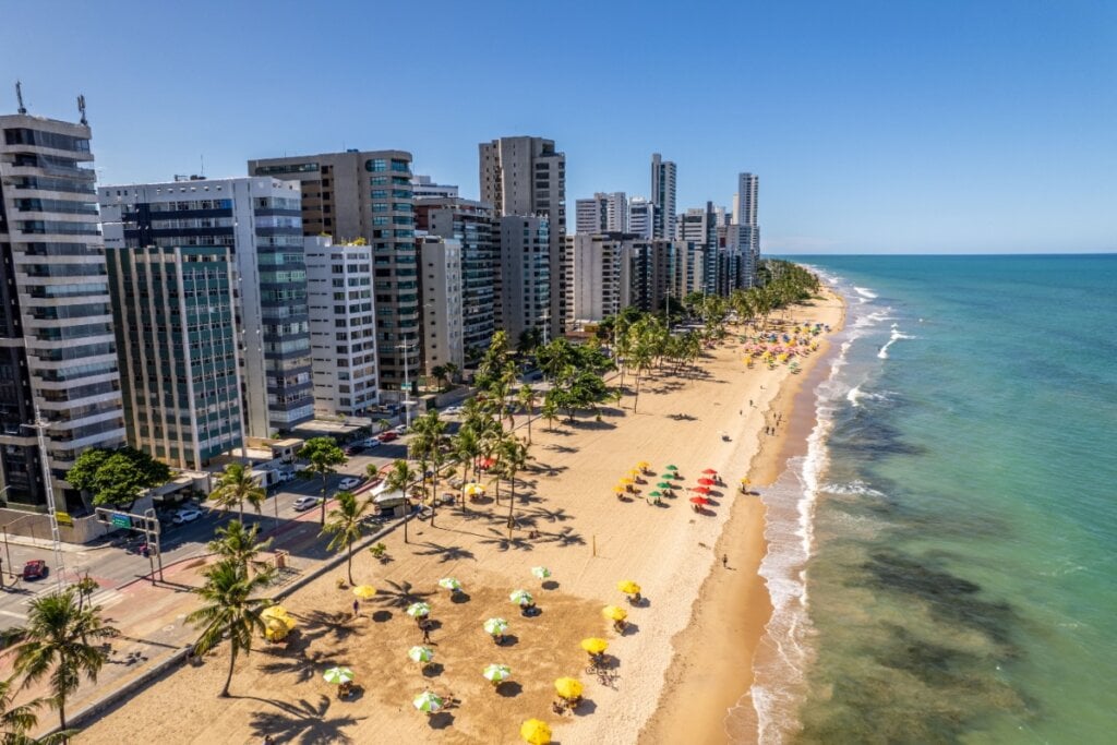 Orla de Boa Viagem, em Recife, exibindo praia, coqueiros e, atrás, prédios