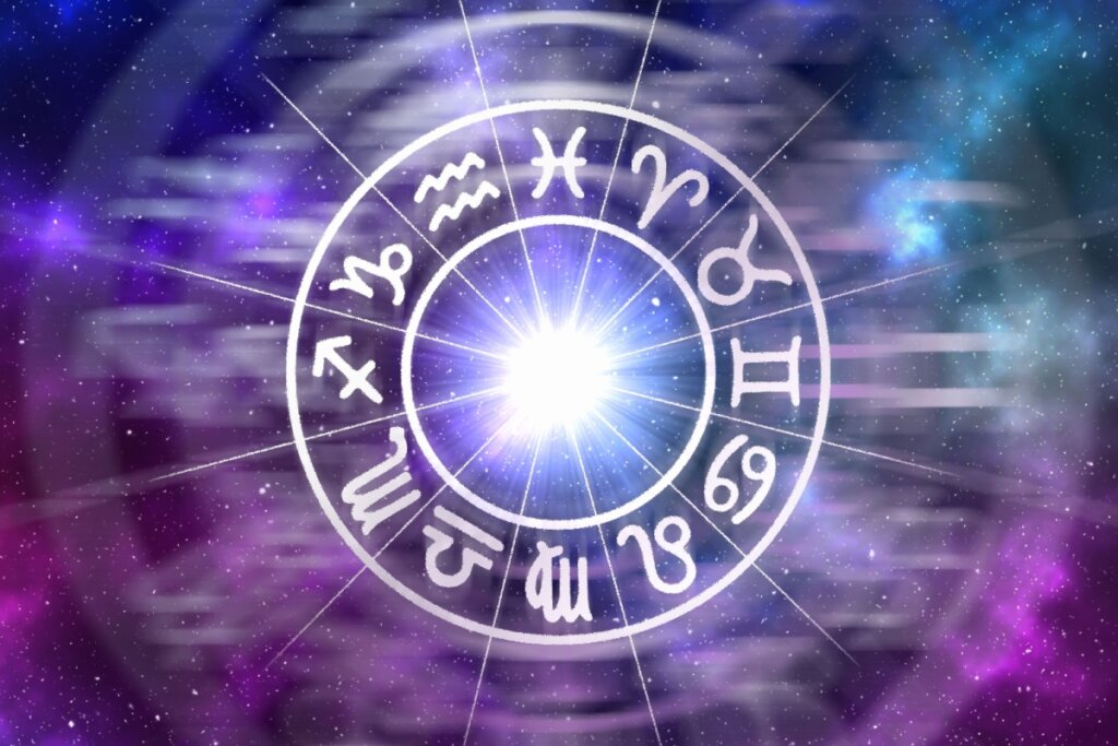 Roda do zodíaco com os 12 signos em fundo estrelado em tons de roxo, rosa e azul